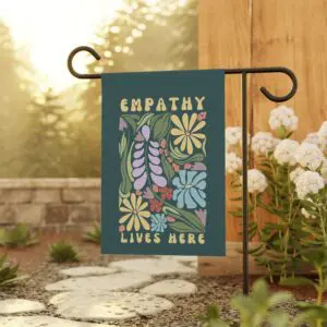 'Empathy Lives Here' floral garden flag displayed outdoors